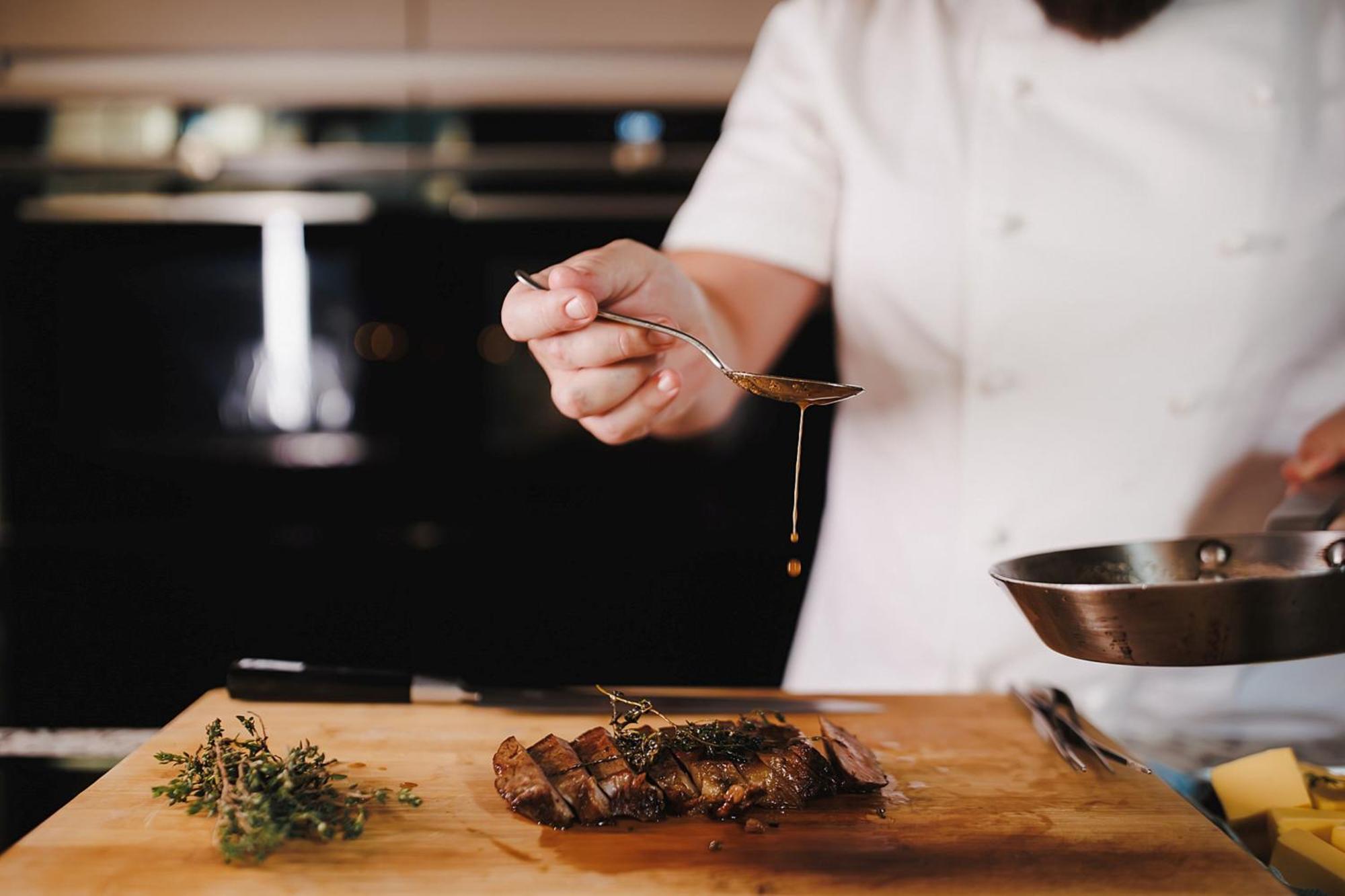 Stock Exchange Hotel, Manchester, Autograph Collection Esterno foto A chef seasoning a dish